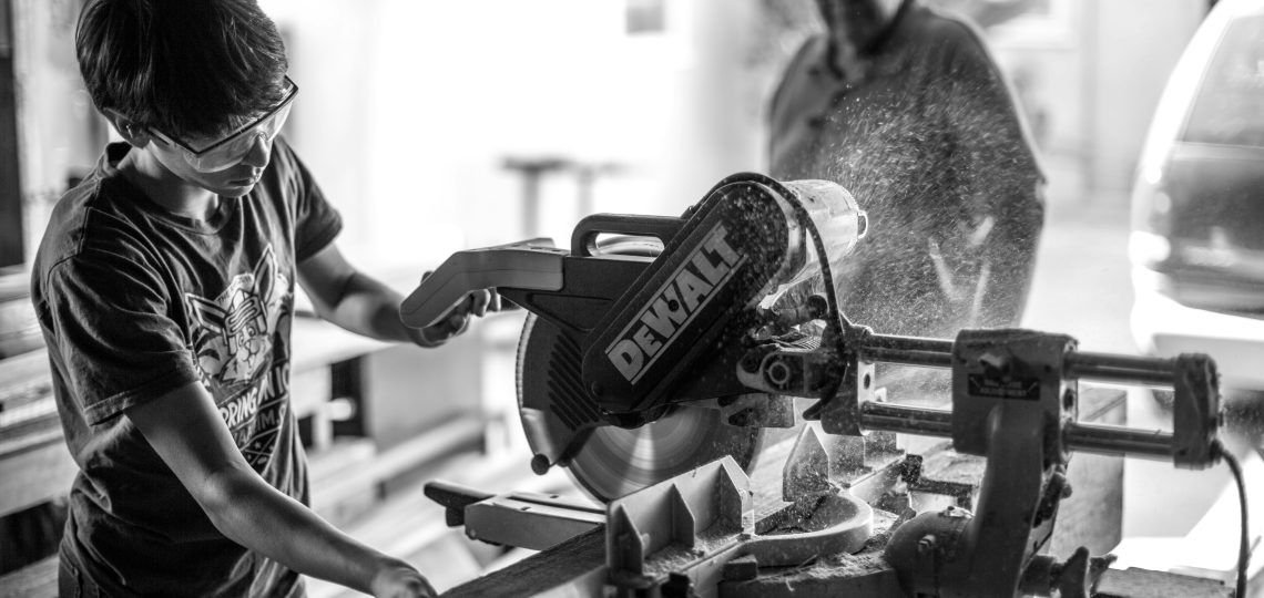 Black and white phot of blue collar workers using hardware tools