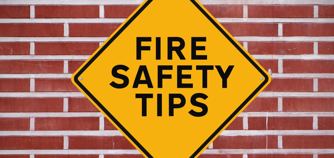 yellow sign stating fire safety tips on a brick background