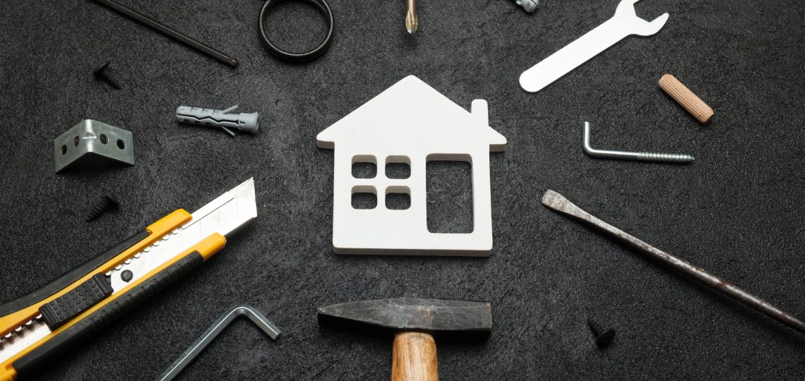 tools scattered around wooden house shape